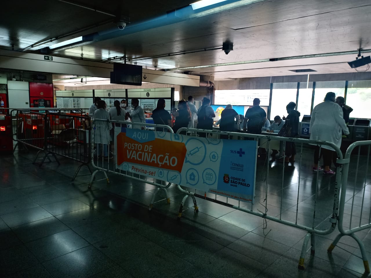Na imagem há grades separando um pequeno local onde estava ocorrendo a ação. Na grade tem um banner escrito 